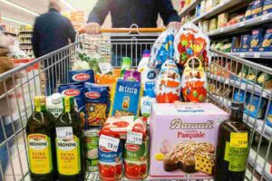 Spesa di Pasqua 2026: carrello con Colomba Bauli, uova Kinder, pasta Barilla e olio Monini.