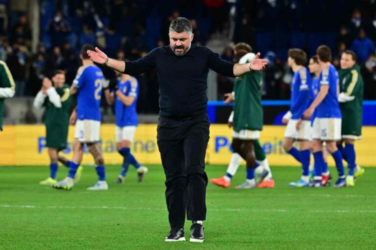 Gennaro Gattuso esulta a braccia aperte sul campo con i giocatori dell'Italia sullo sfondo.