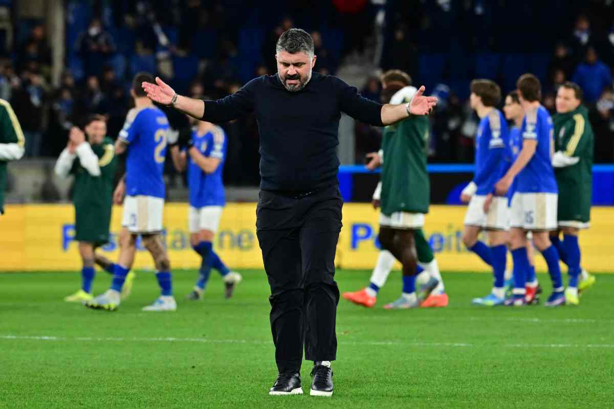 Gennaro Gattuso esulta a braccia aperte sul campo con i giocatori dell'Italia sullo sfondo.