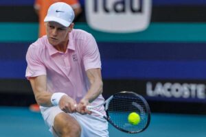 Jannik Sinner colpisce la pallina da tennis con un rovescio a doppie mani.