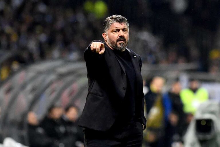 Rino Gattuso in giacca nera mentre indica qualcosa in campo con espressione apprensiva.